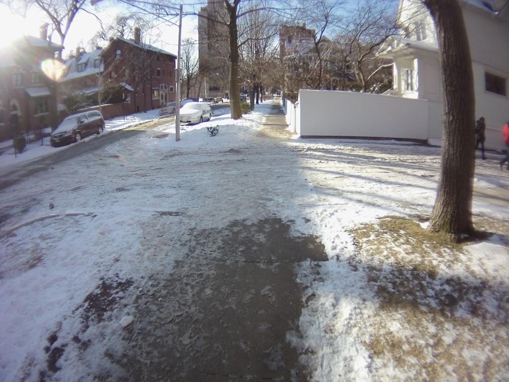 Snow clearance stops at an alleyway entrance.